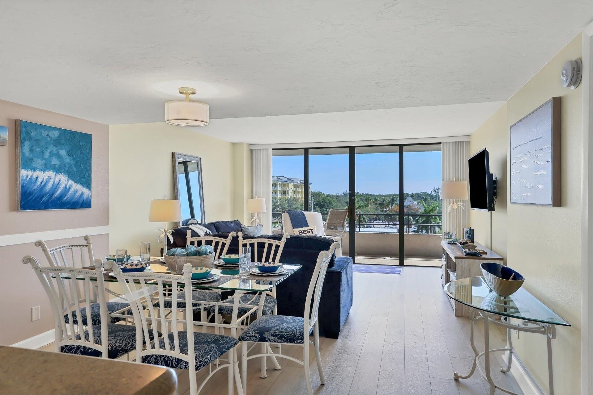 Un grand salon avec balcon, une table à manger avec des chaises et un canapé.