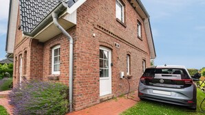 Ein Ziegelhaus mit einem Auto auf der Auffahrt.