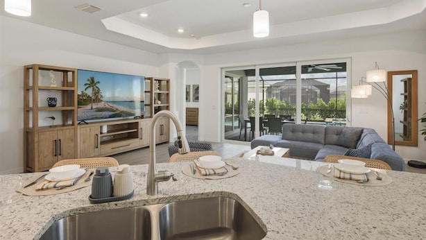 A modern kitchen with granite countertops, a built-in oven, and a large island with a sink. - Heritage Landing Resort 4 Bedroom House Private Pool+Spa 4 Home (Punta Gorda)