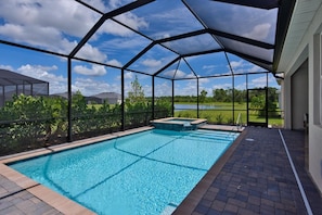 An outdoor swimming pool with a clear view of a lake and trees in the background. - Heritage Landing Resort 4 Bedroom House Private Pool+Spa 4 Home (Punta Gorda)