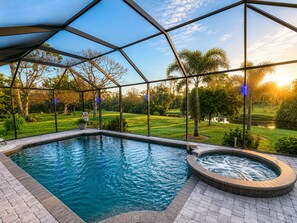 A swimming pool with a hot tub, surrounded by a glass enclosure, and a view of a golf course. - The Sanctuary - Private Pool+spa Vacation Home - Only 5 Minutes To The Gulf Coast! 3 Bedroom Home (Rotonda West)