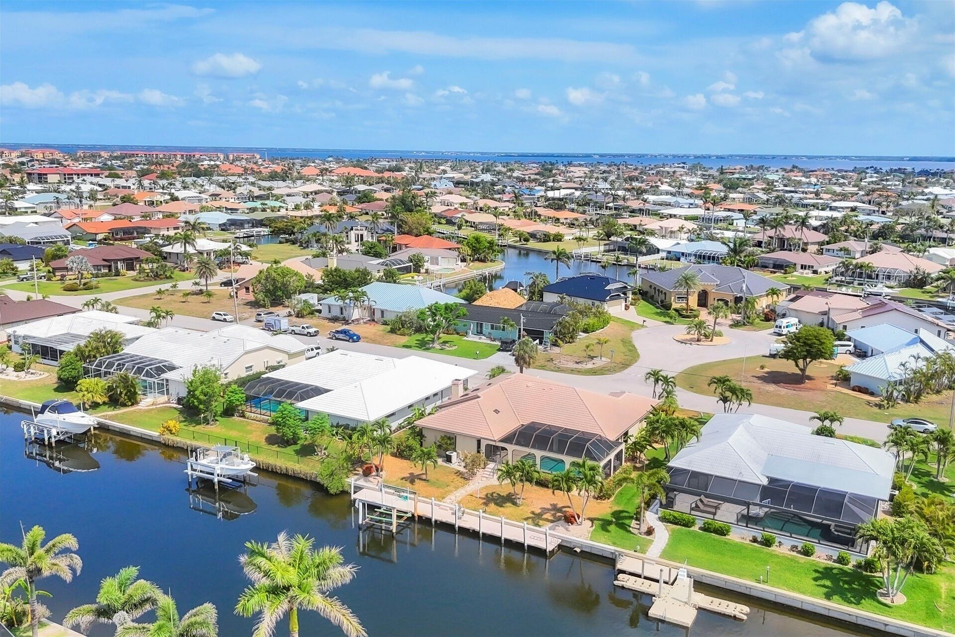 Un quartier résidentiel comprenant des maisons, un port de plaisance et une vaste étendue d’eau.