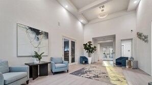 A spacious living area with a large abstract painting, a coffee table, two armchairs, a potted plant, and a rug. - Heritage Landing Golf And Country Club Vacation Condo 3 Bedroom Condo (Punta Gorda)