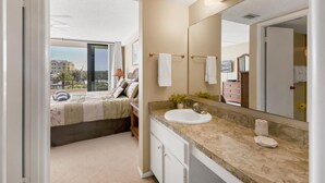 A hotel bathroom with a large mirror, a sink, and a bed with a view of the city. - Anchorage Resort 2 bedroom, 4th Floor Condo Southern View Siesta Key 2 Condo (Siesta Key)