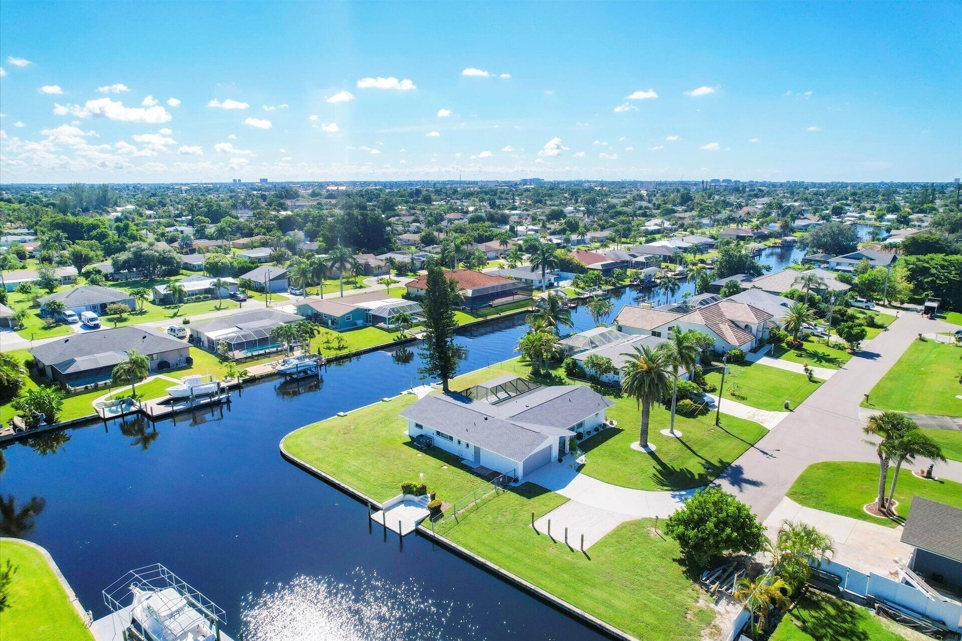 An aerial view of a residential area with houses, a canal, and a dock.