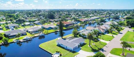 An aerial view of a residential area with houses, a canal, and a dock.