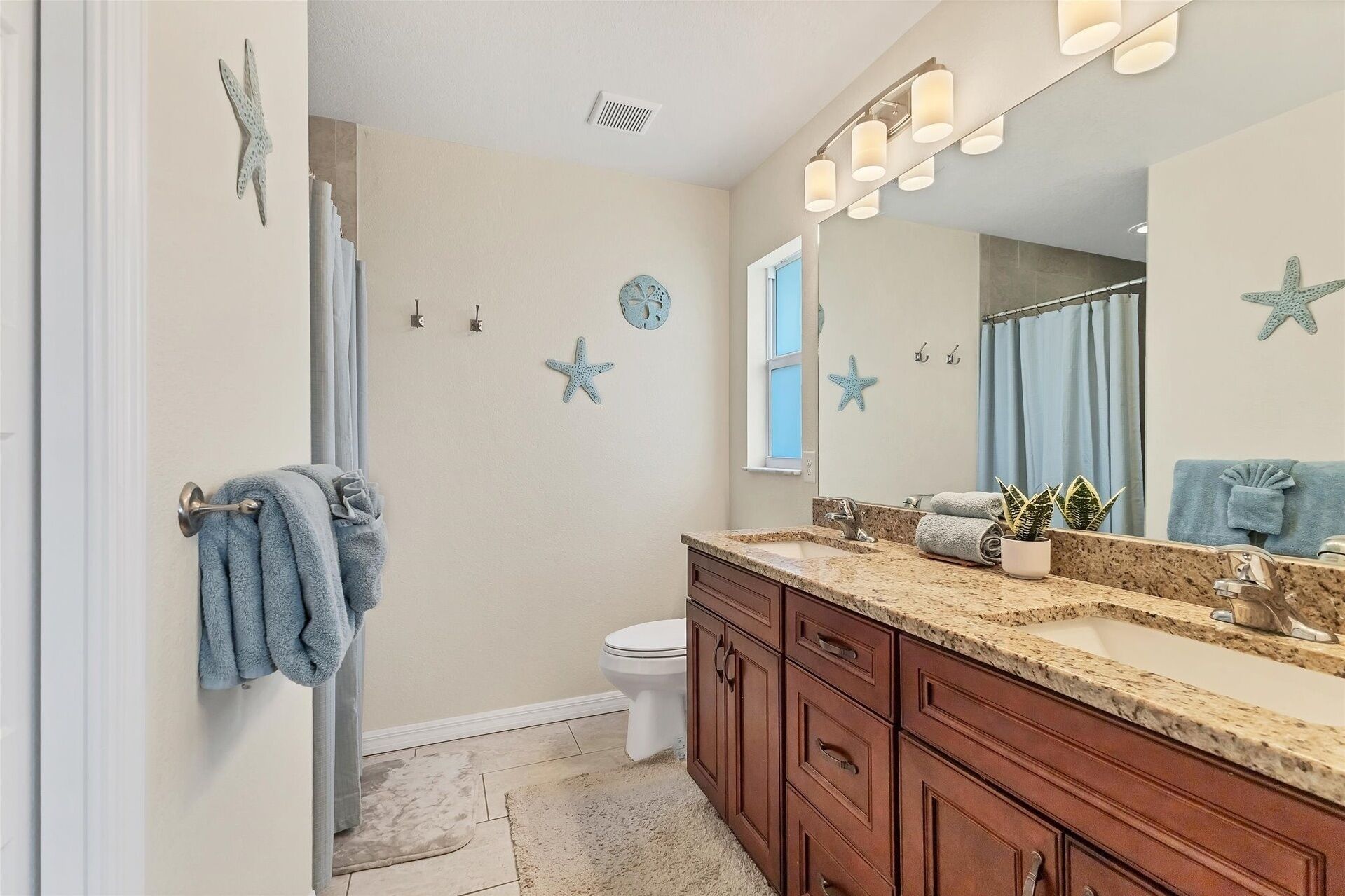 A bathroom with a vanity, a toilet, and a shower area.