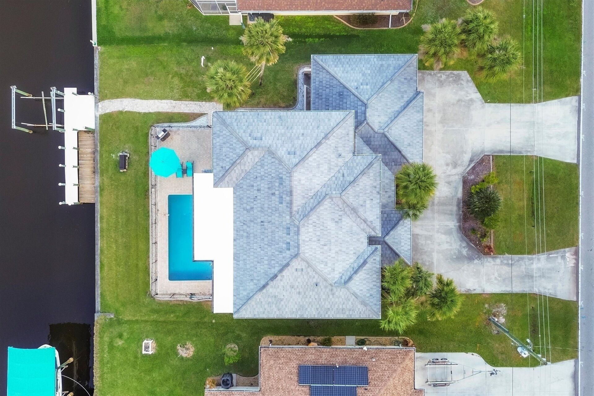 Luchtbeeld van een wooncomplex met een groot huis, een zwembad en een aanlegsteiger.
