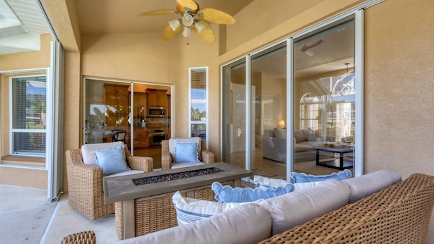 A sunlit patio with wicker furniture, a dining table, and a ceiling fan. - Punta Gorda Isles 3 Bedroom Pool+Hot Tub Home 2 Home (Punta Gorda)