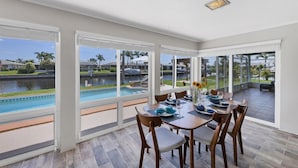 A dining area with a view of a swimming pool and a canal. - Punta Gorda Isles 2-Bedroom Private Pool Home on Canal with Dock 2 Home (Punta Gorda)