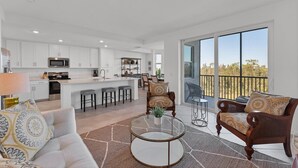 A spacious living area with a kitchen, a dining area, and a balcony with a view. - Heritage Landing Golf Club 2 Bedroom Condo 30 Night Minimum 2 Condo (Punta Gorda)