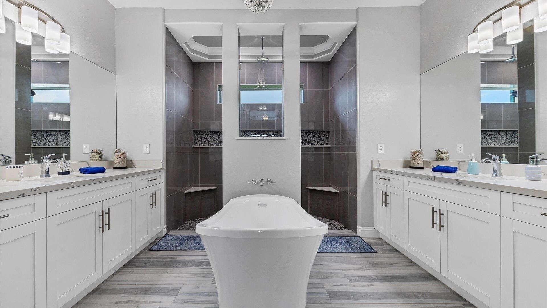 Une salle de bain moderne avec une baignoire sur pieds, deux vasques et un grand miroir.
