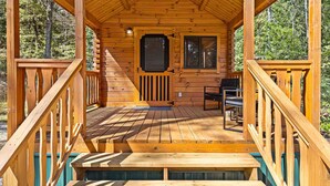Eine Holzhütte mit Veranda, einer Tür und einem Fenster.