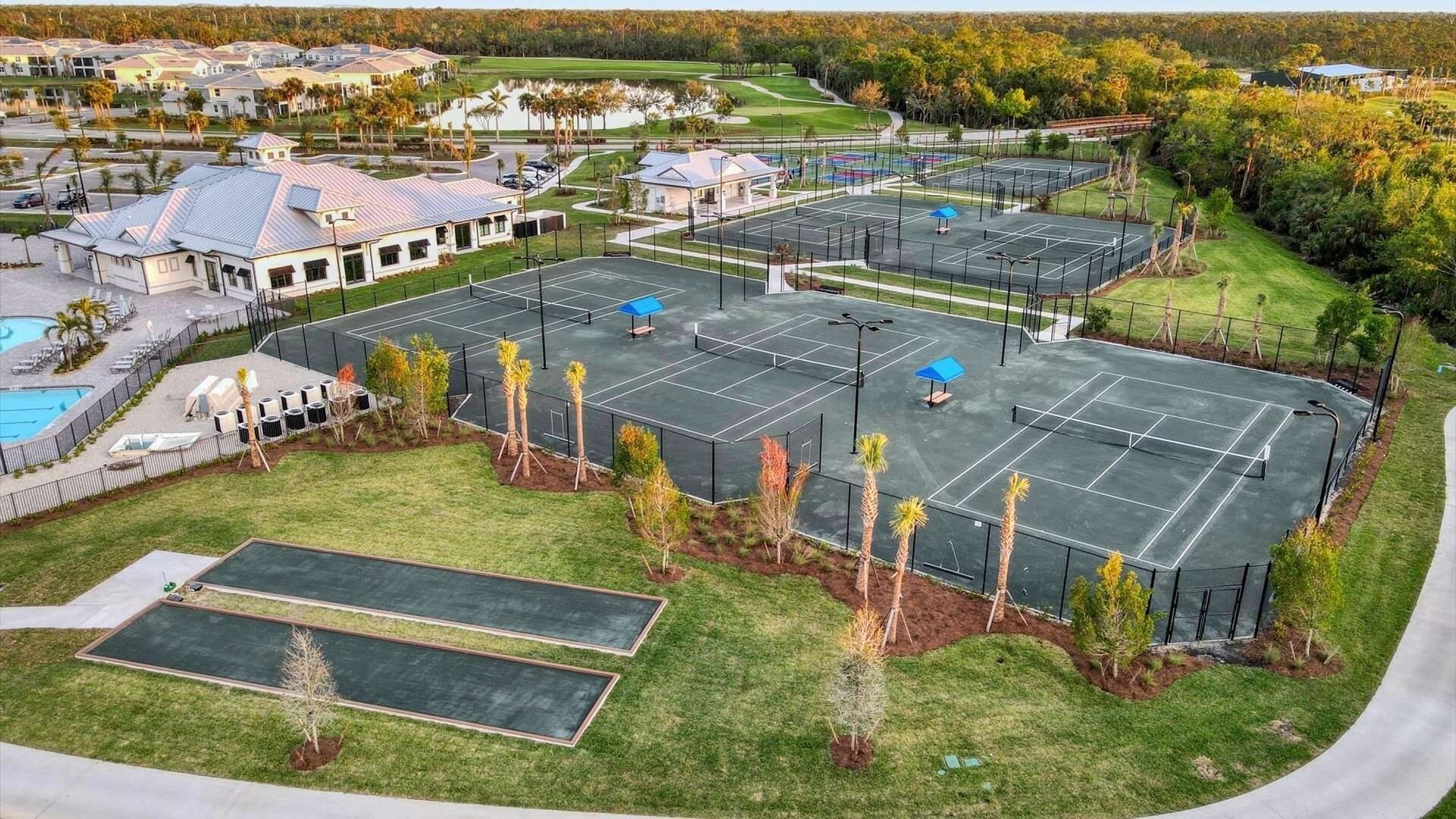 Un ampli complex esportiu de tennis a l'aire lliure, amb diverses pistes, una piscina i zones verdes al voltant.
