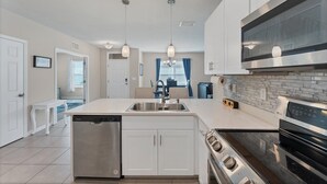 A modern kitchen with white cabinetry, stainless steel appliances, and pendant lighting. - Punta Gorda 2 Bedroom Home Dog Friendly! 2 Home (Punta Gorda)