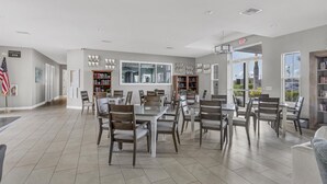 A spacious dining area with a high ceiling, multiple tables, and chairs. There are bookshelves along the walls and a flag on the left. - Punta Gorda 2 Bedroom Home Dog Friendly! 2 Home (Punta Gorda)