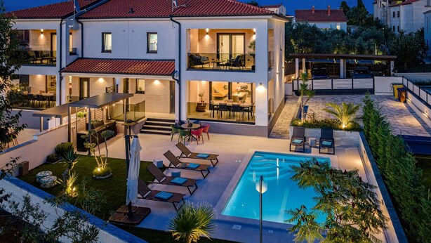 A two-story house with a swimming pool, outdoor seating, and a well-lit patio area. - Villa Polaris by Villas Guide (Pula)