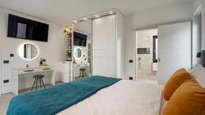 A modern bedroom with a bed, a desk, and a walk-in closet. - Villa Polaris by Villas Guide (Pula)