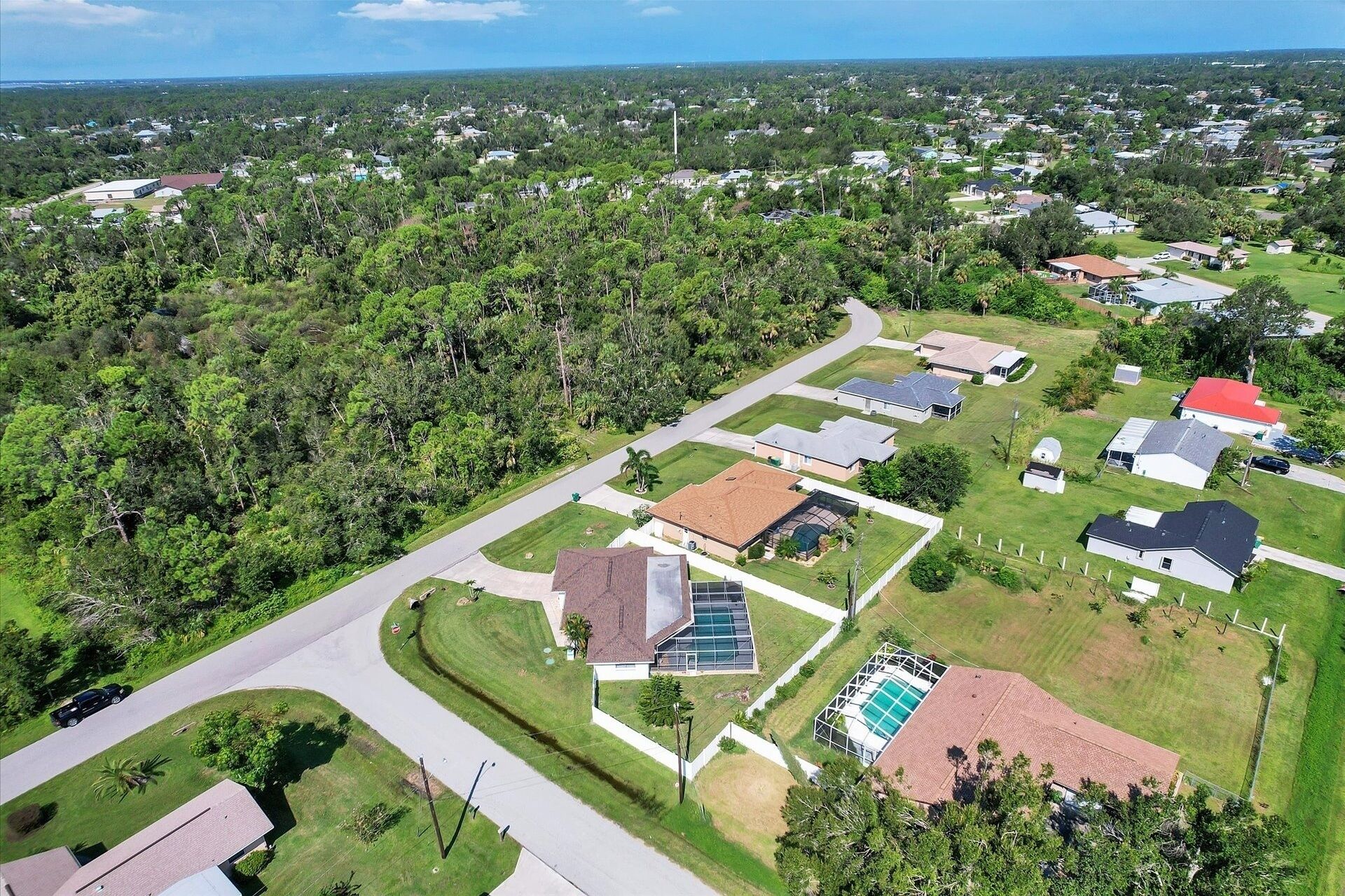 Vue aérienne d’un quartier résidentiel avec des maisons, des routes et de la végétation.