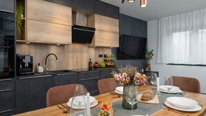 A modern kitchen with wooden cabinetry, a built-in oven, and a coffee machine. - Villa Antares by Villas Guide (Pula)