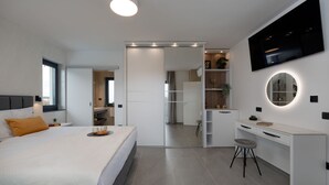 A modern bedroom with a bed, a desk, and a TV. - Villa Antares by Villas Guide (Pula)