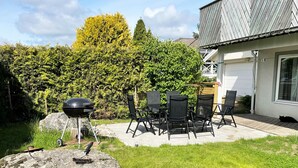 A patio with a grill, chairs, and a table. - Lovely apartment, perfect for exploring Tjörn and Orust | SE09153 (Varekil)