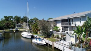 A waterfront property with a dock, a sailboat, and a two-story house with a balcony. - Lemon Bay Waterfront Condo W Patio, 5 Miles To Gulf Beaches 2 Bedroom Condo (Englewood)