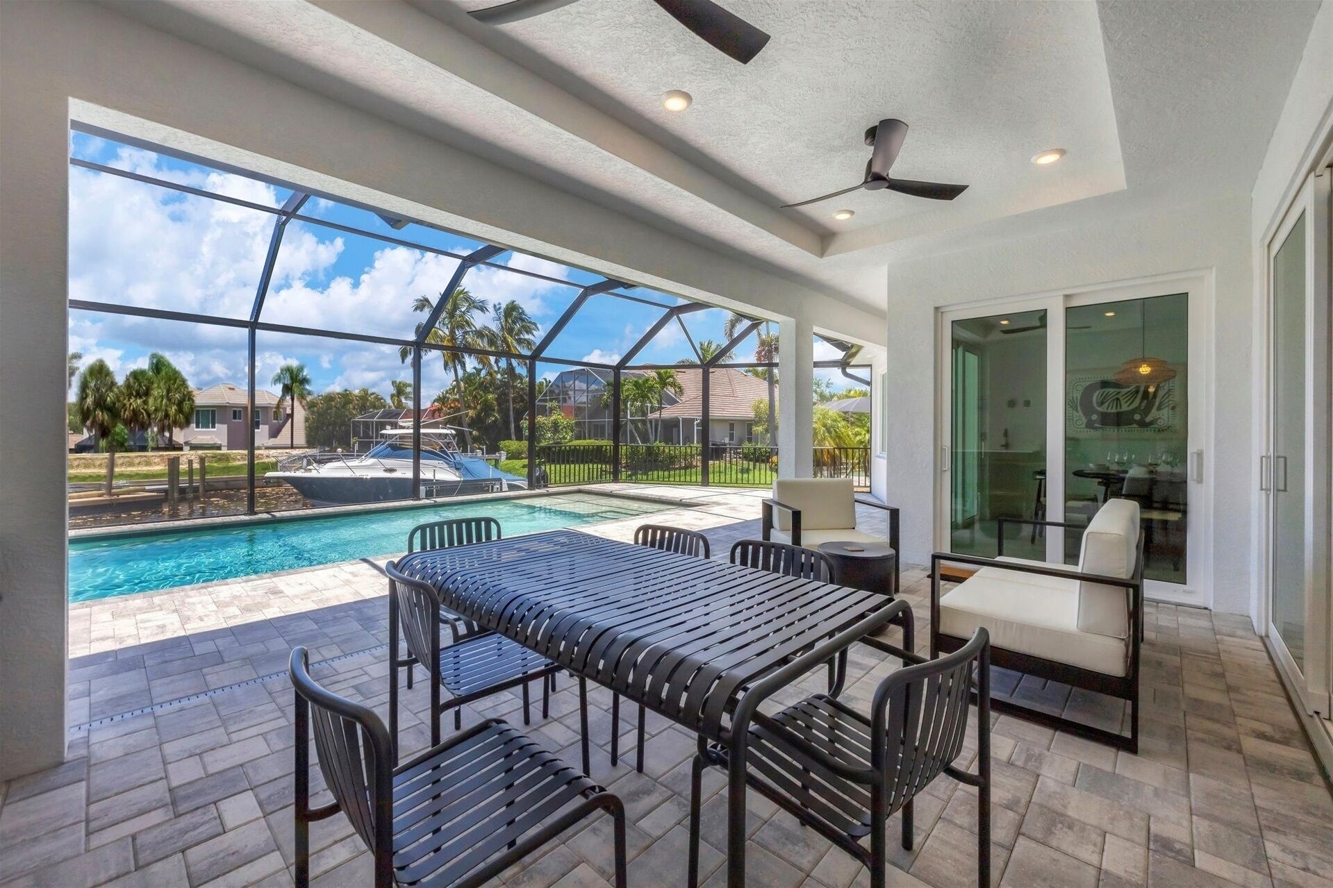 Une vaste terrasse dotée d’une piscine, de mobilier d’extérieur et offrant une vue sur un quartier résidentiel.