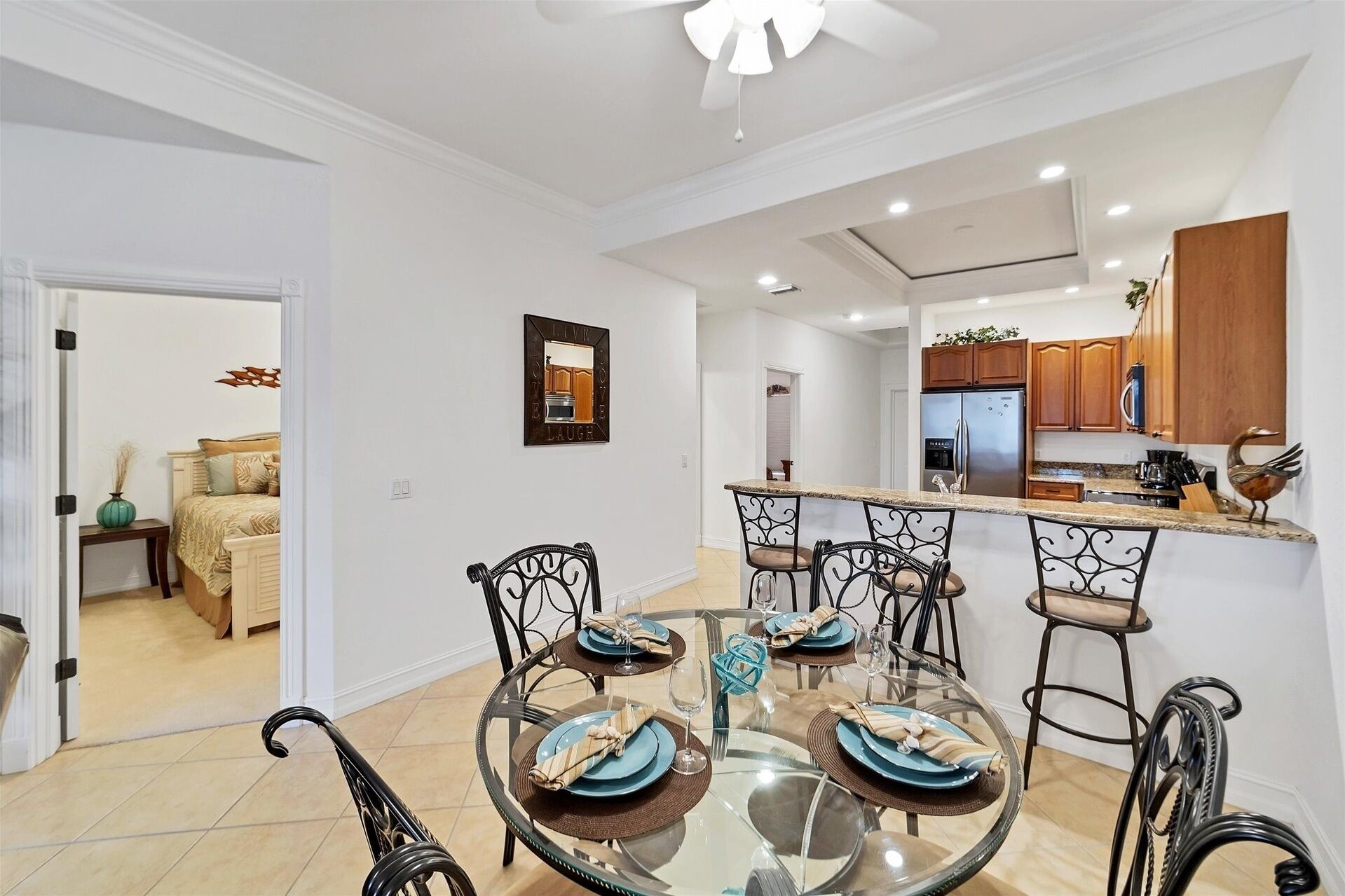 A modern kitchen with wooden cabinets and a stainless steel refrigerator.