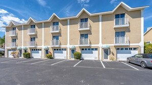A multi-story hotel with a beige facade, white balconies, and a parking lot. - Relaxing Townhome By Lemon Bay, Minutes To Beach 2 Bedroom Townhouse (Englewood)