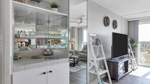 Ein modernes Wohnzimmer mit einer Vitrine, einem Sofa, einem Fernsehtisch und einem Balkon mit Blick.