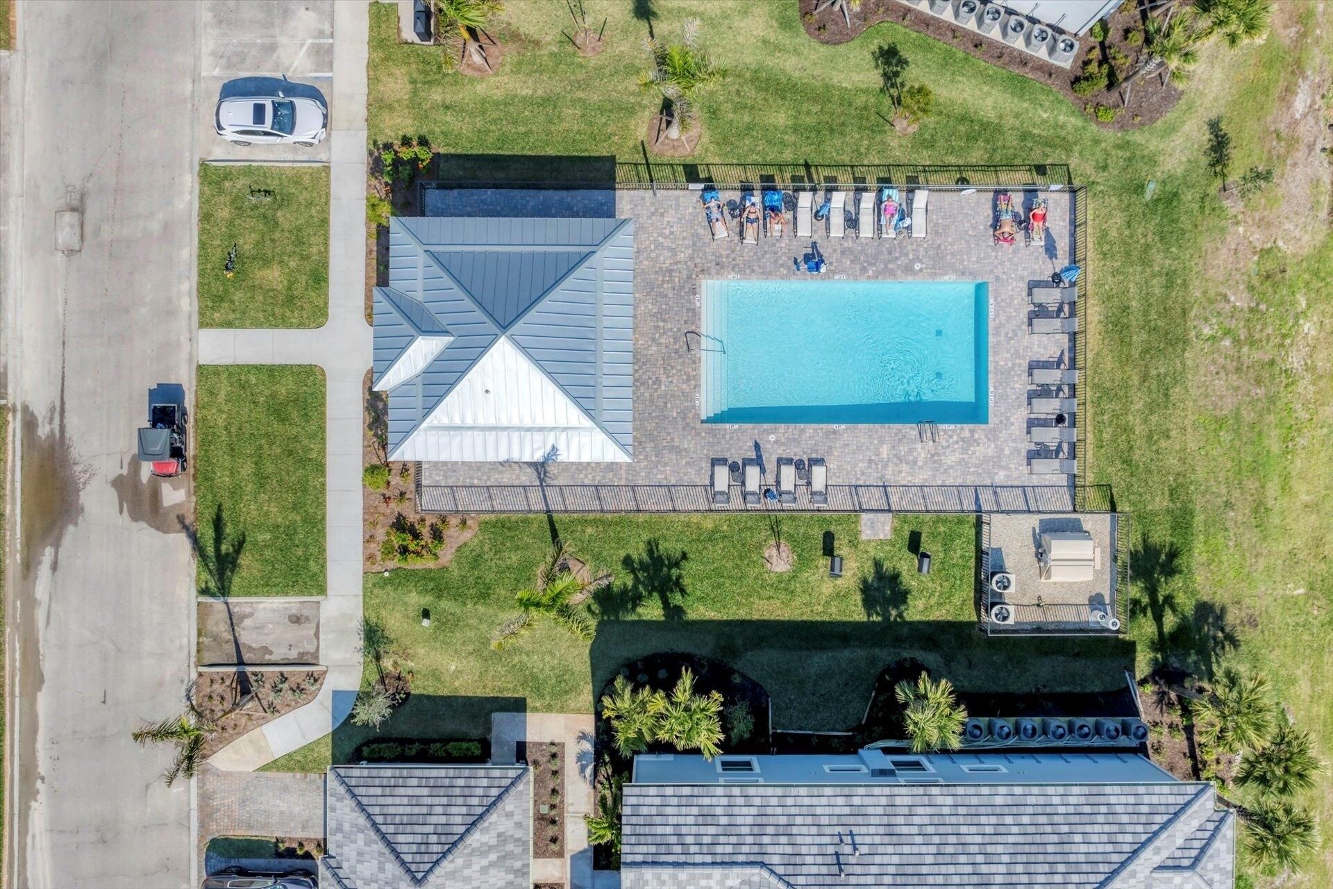 Vista aérea de una propiedad con piscina, un patio cubierto y un estacionamiento.