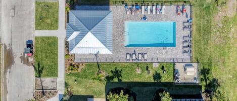 Vista aérea de una propiedad con piscina, un patio cubierto y un estacionamiento.