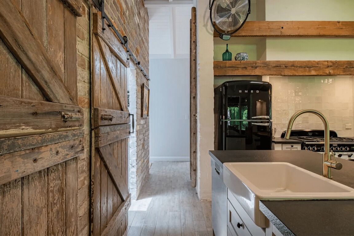 Une cuisine avec des murs en bois, un évier et une cuisinière.