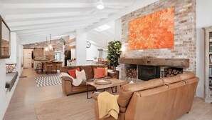 Un salon spacieux avec un grand canapé en cuir, une table basse et une cheminée.