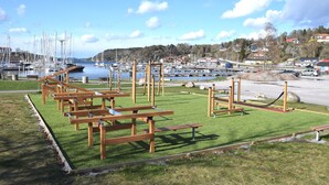 Un port de plaisance doté de tables de pique-nique en bois et d’une zone herbeuse.