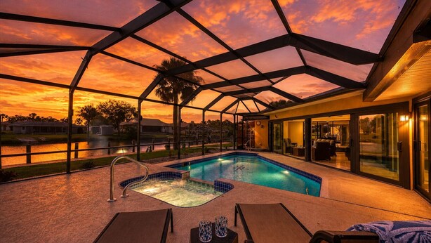 Piscina com hidromassagem, espreguiçadeiras e um espaço coberto com terraço.