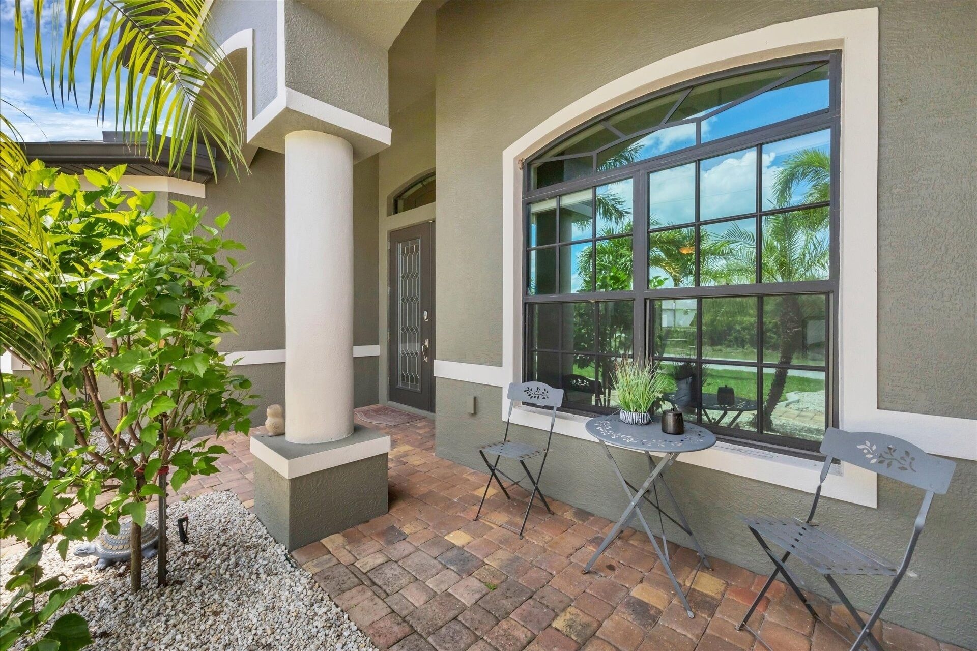 A patio area with a curved window, outdoor seating, and a decorative turtle statue.