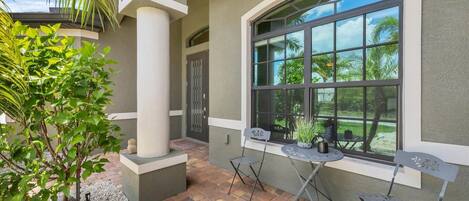 A patio area with a curved window, outdoor seating, and a decorative turtle statue.