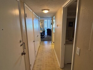 A hallway with a tiled floor leading to a room with a door. - Vantage Pointe 138 - Condo Across The Street In Daytona Beach 1 Bedroom Condo (Daytona Beach)