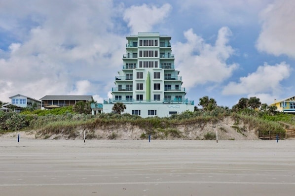 A multi-story hotel with a modern design, located near a beach with a sandy foreground and a clear sky. - Oceanfront Condo With Beautiful Views 2 Bedroom Condo (New Smyrna Beach)