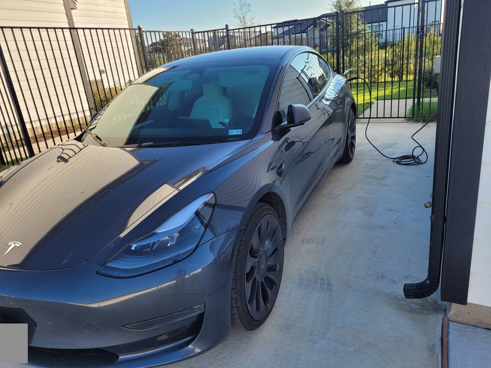 Ein geparktes Auto auf einer Auffahrt mit einem verschlossenen Eingangstor.