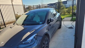 Ein geparktes Auto auf einer Auffahrt mit einem verschlossenen Eingangstor.