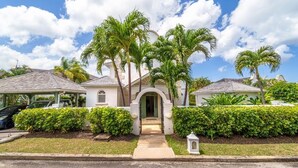 A two-story house with a covered porch, palm trees, and a well-maintained lawn. - Sugar Hill - Jade Vine 3 Bedroom Villa (Holetown)