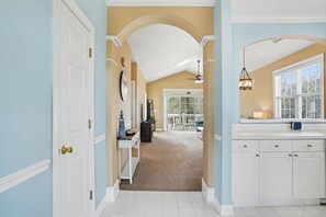 A hallway with a white door, a white console table, and a ceiling fan. - Wedgewood #234- End Corner Unit with Golf Course Views! (North Myrtle Beach)