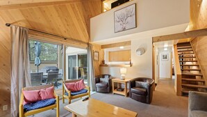 Un intérieur chaleureux avec des meubles en bois, un coin repas et un escalier.