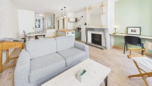 A modern living room with a grey sofa, wooden coffee table, and a fireplace. - Cosy apartment in the center of town - Philotée 2 (Clermont-Ferrand)