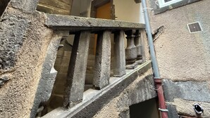 A stone staircase leading to an upper floor, with a window and a door visible on the right. - Cosy apartment in the center of town - Philotée 2 (Clermont-Ferrand)
