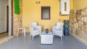 A patio with two white wicker chairs, a small white table, and a potted plant. - Casa Carolina with Private Terrace, Wi-Fi and Air Conditioning (Pozzallo)