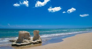 Een strand met heldere luchten en rustig water.